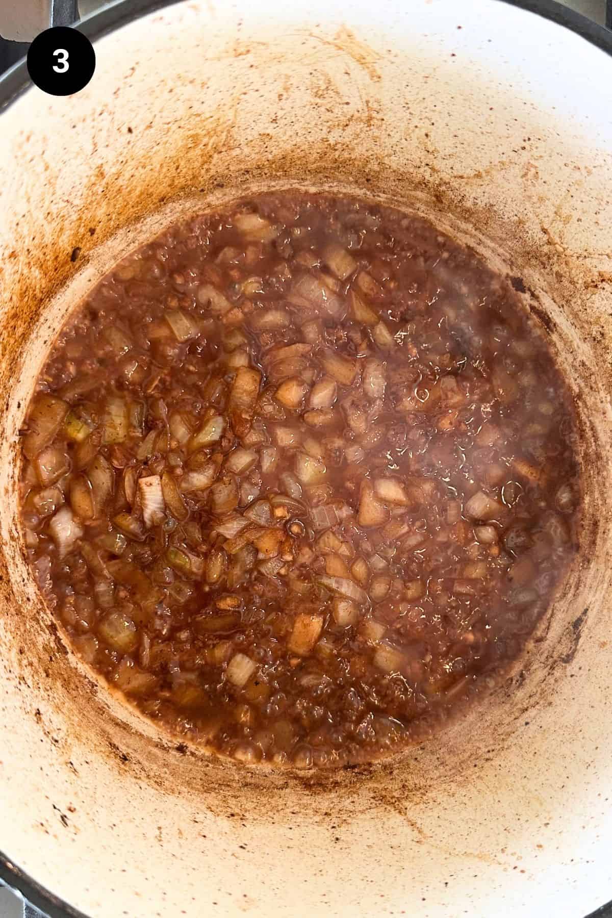 Deglazing the Dutch oven with red wine.