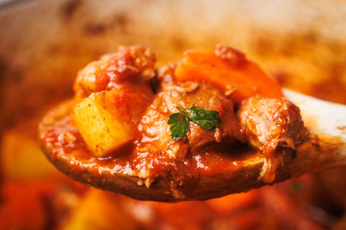 Lamb stew on a wooden spoon.