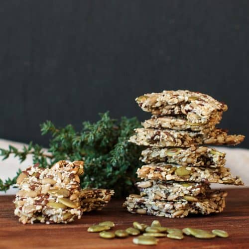 Stack of seed crackers on a wooden board.