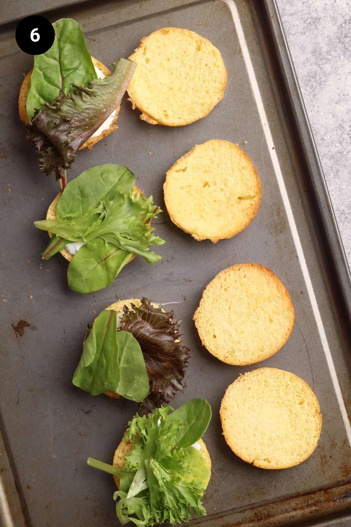Lamb sliders being assembled on a baking tray.