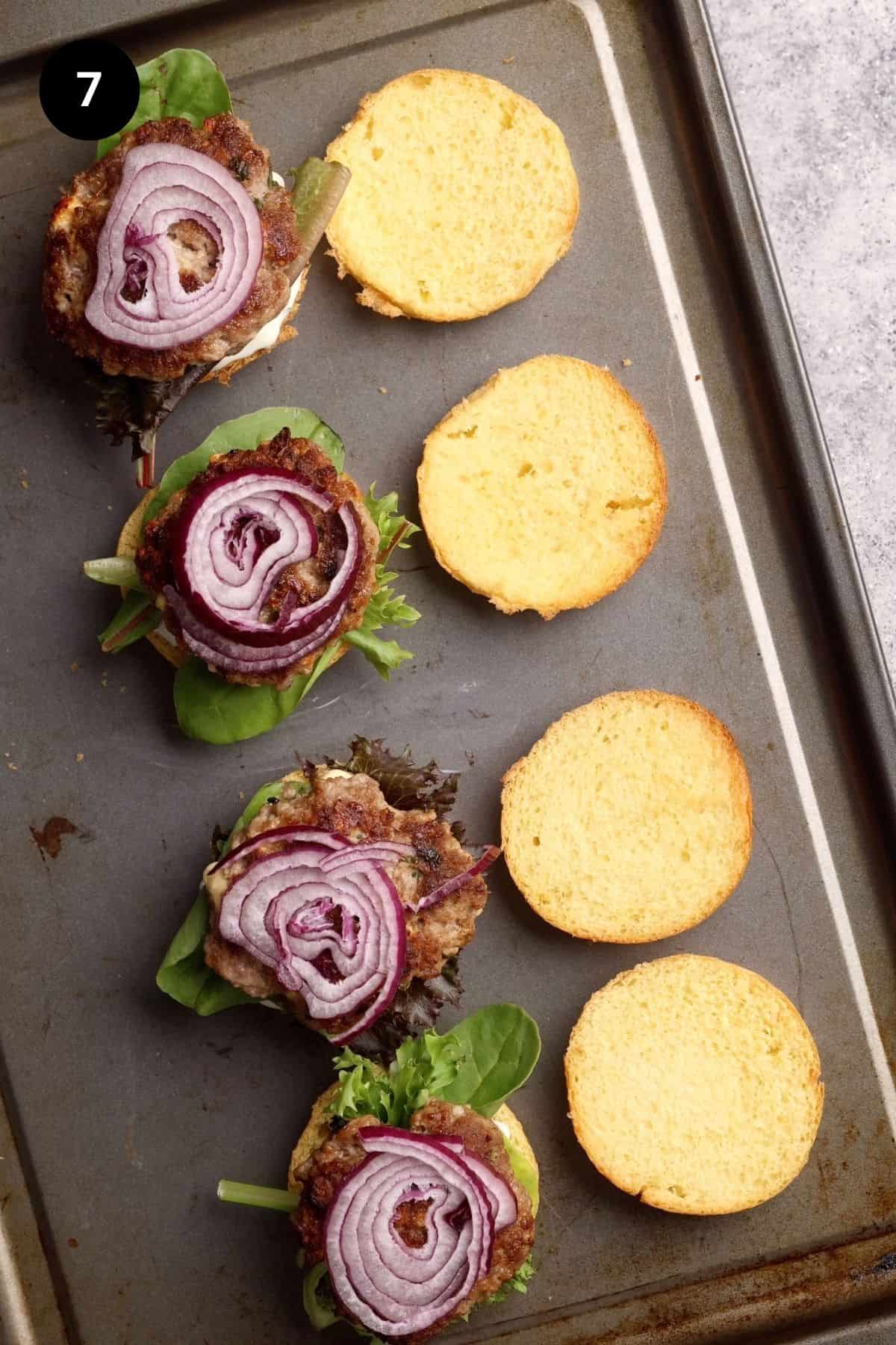 Lamb sliders being assembled on a baking tray.
