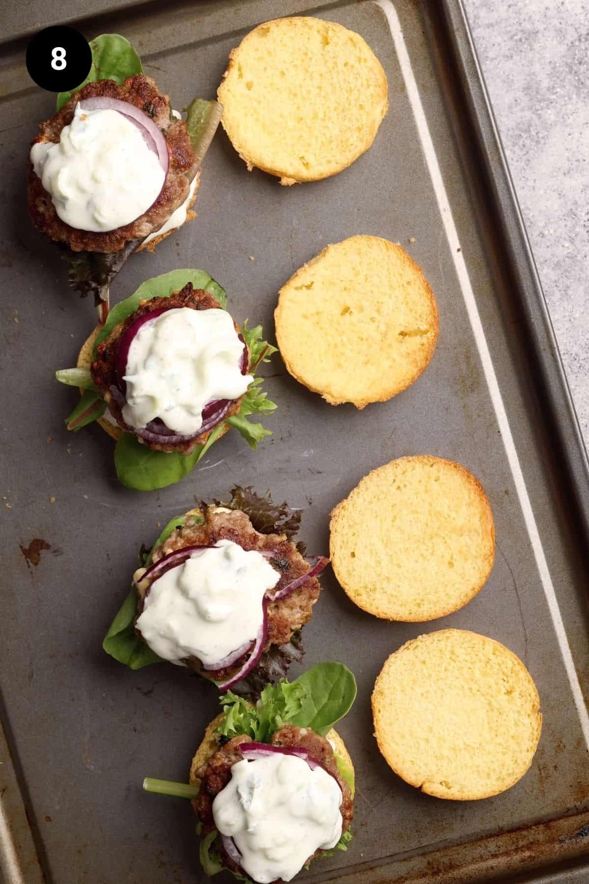 Lamb sliders being assembled on a baking tray.