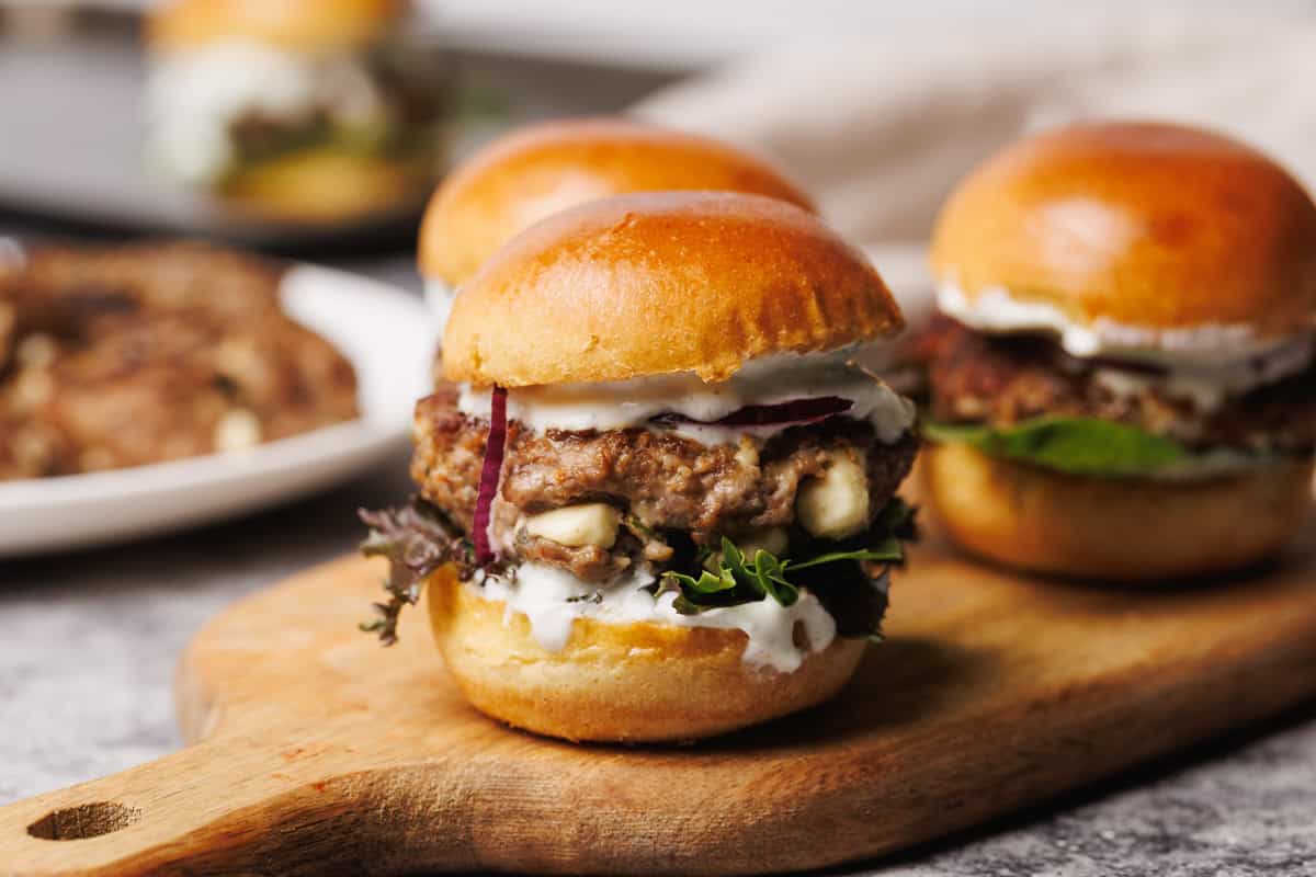 A lamb slider on a wooden board.