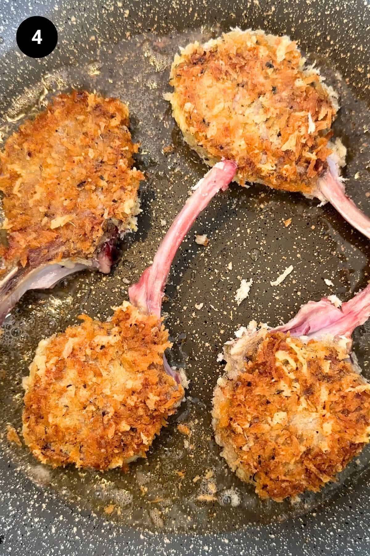 Parmesan crusted lamb chops in a pan being fried.