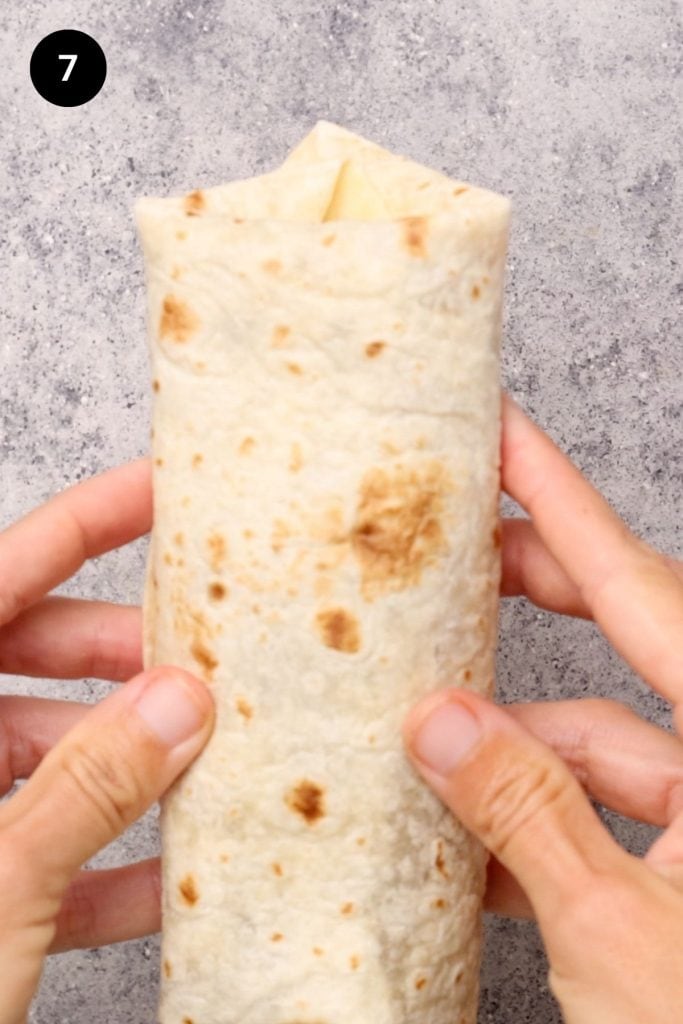 Burrito folded up being held in hand.