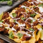 Birria nachos ready to serve on a baking tray.