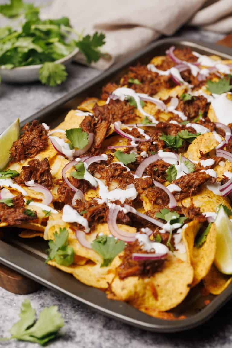 Birria nachos ready to serve on a baking tray.