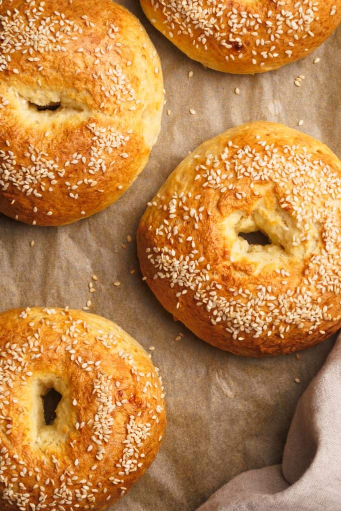 Cottage cheese bagels on a lined baking sheet.