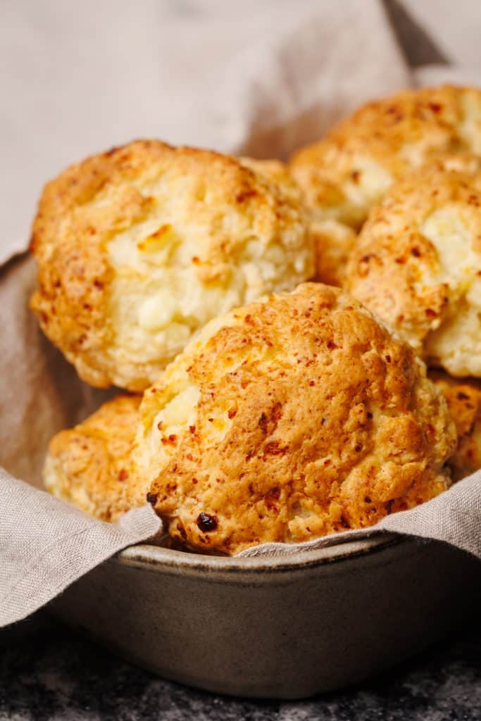 Cottage cheese biscuits in a linen towel in a baking dish.