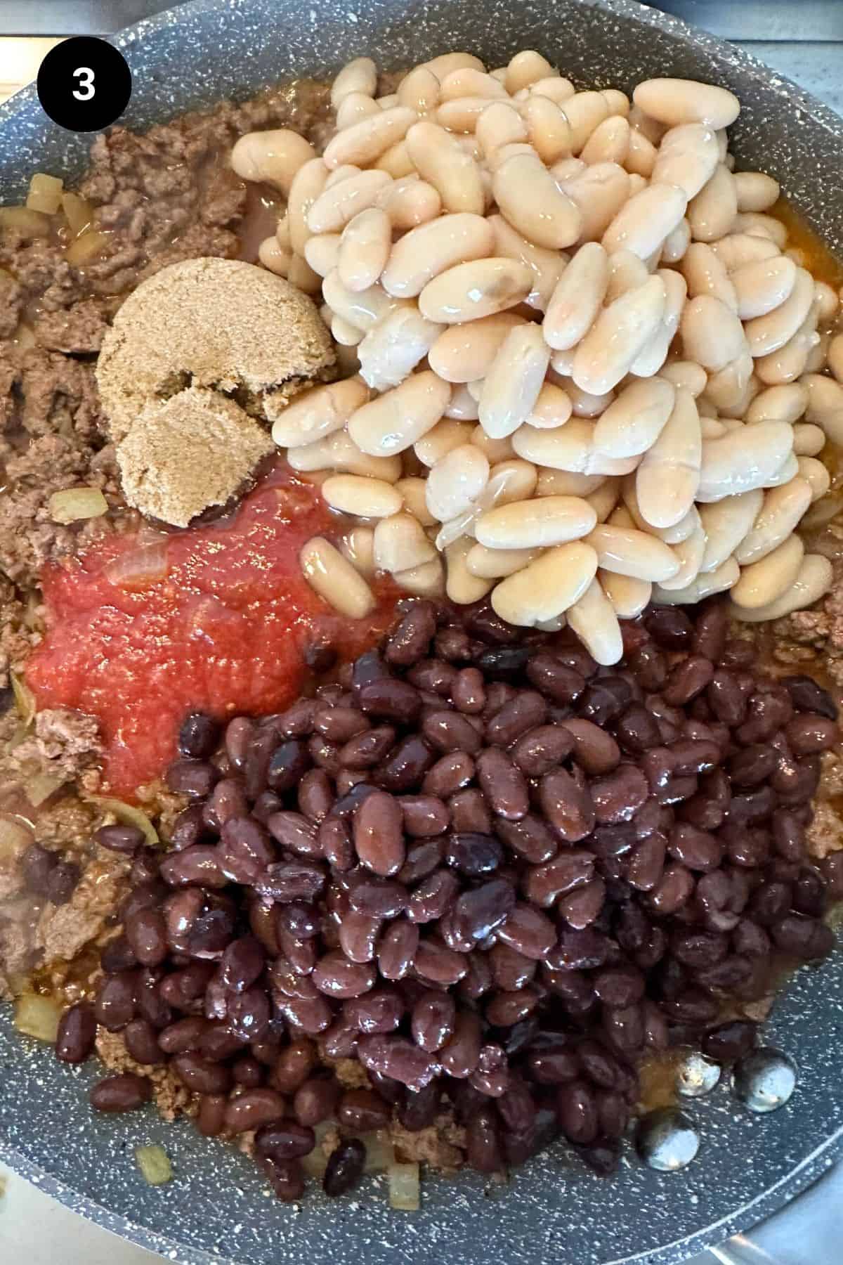 Beans and sugar added to the browned beef.