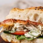 Chicken bacon ranch sandwich on a wooden board.
