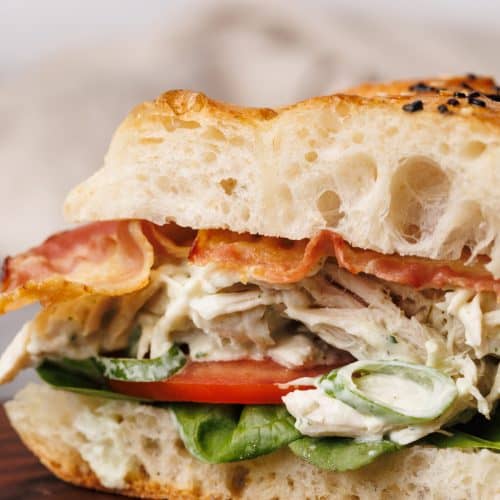 Chicken bacon ranch sandwich on a wooden board.