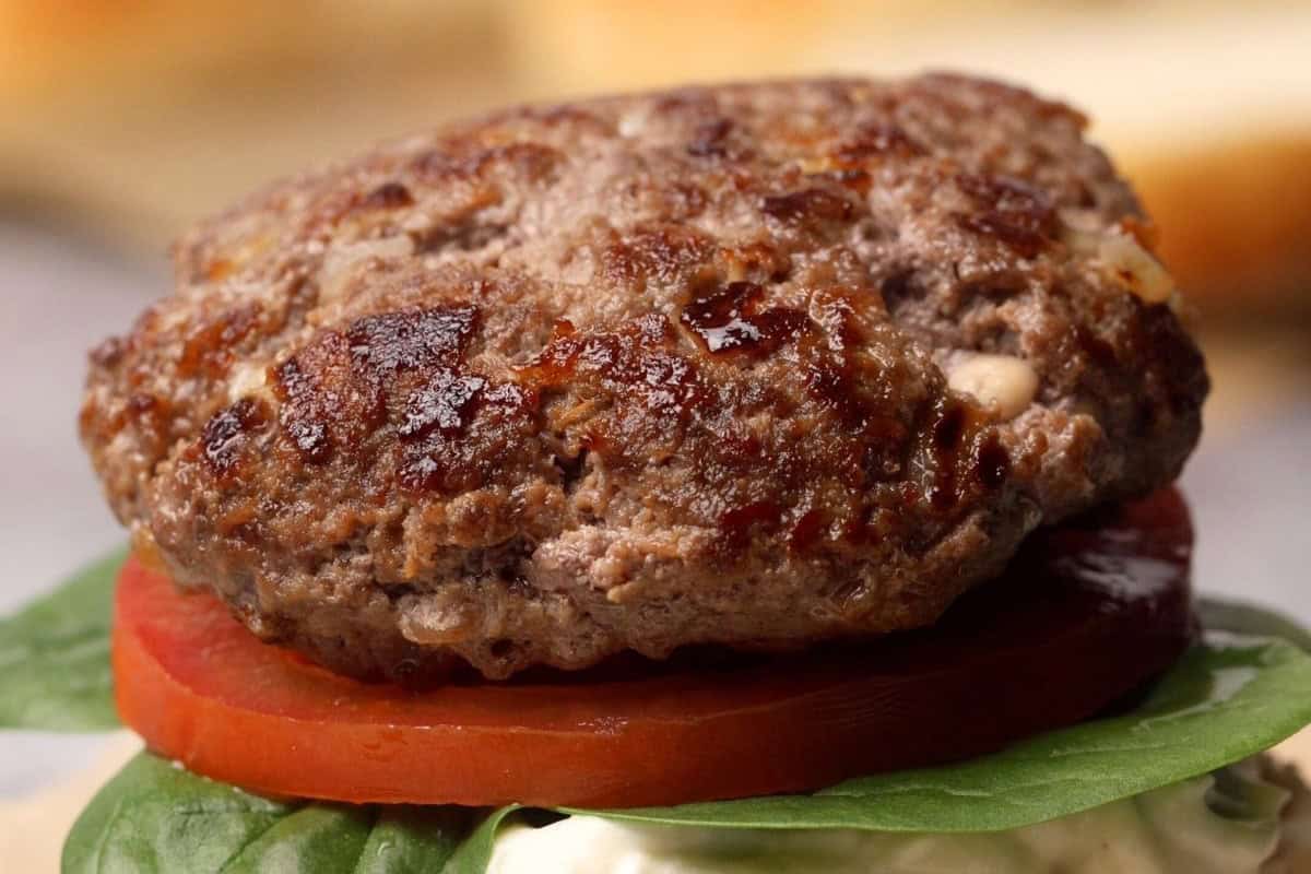 Hamburger patty on a burger without the top bun.