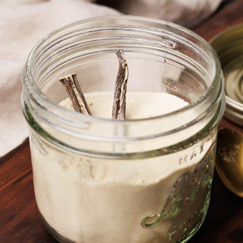 Vanilla powdered coffee creamer in a mason jar on a wooden board.