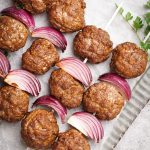 Cooked meatball skewers on a metal plate.