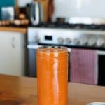 Romesco sauce in a mason jar on a wooden kitchen bench.