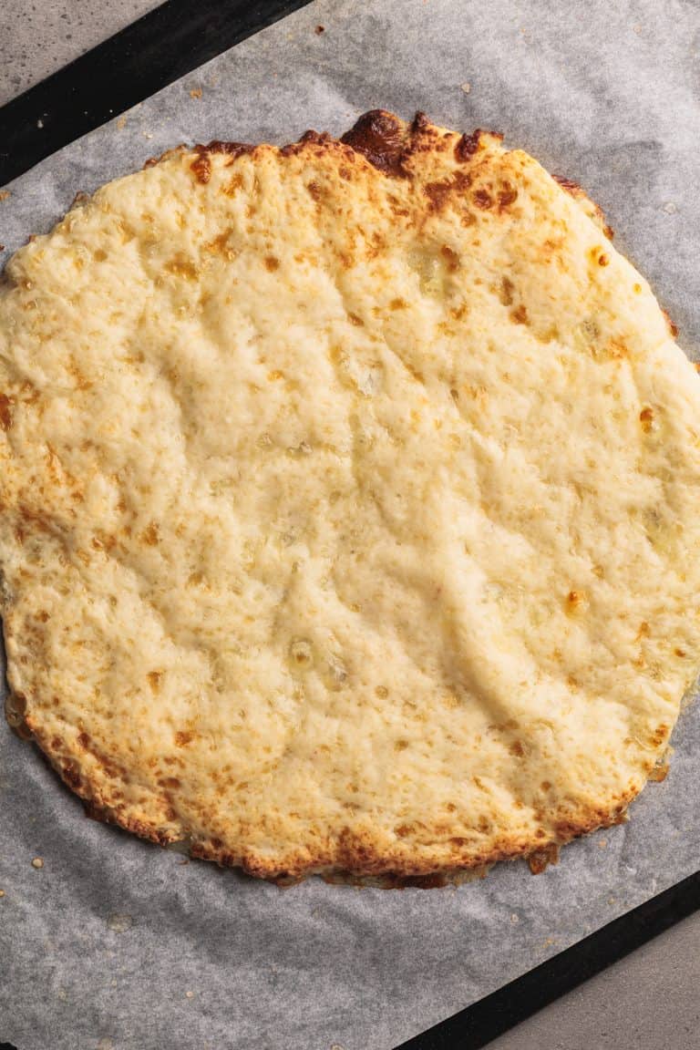 Cottage cheese pizza crust on parchment paper.